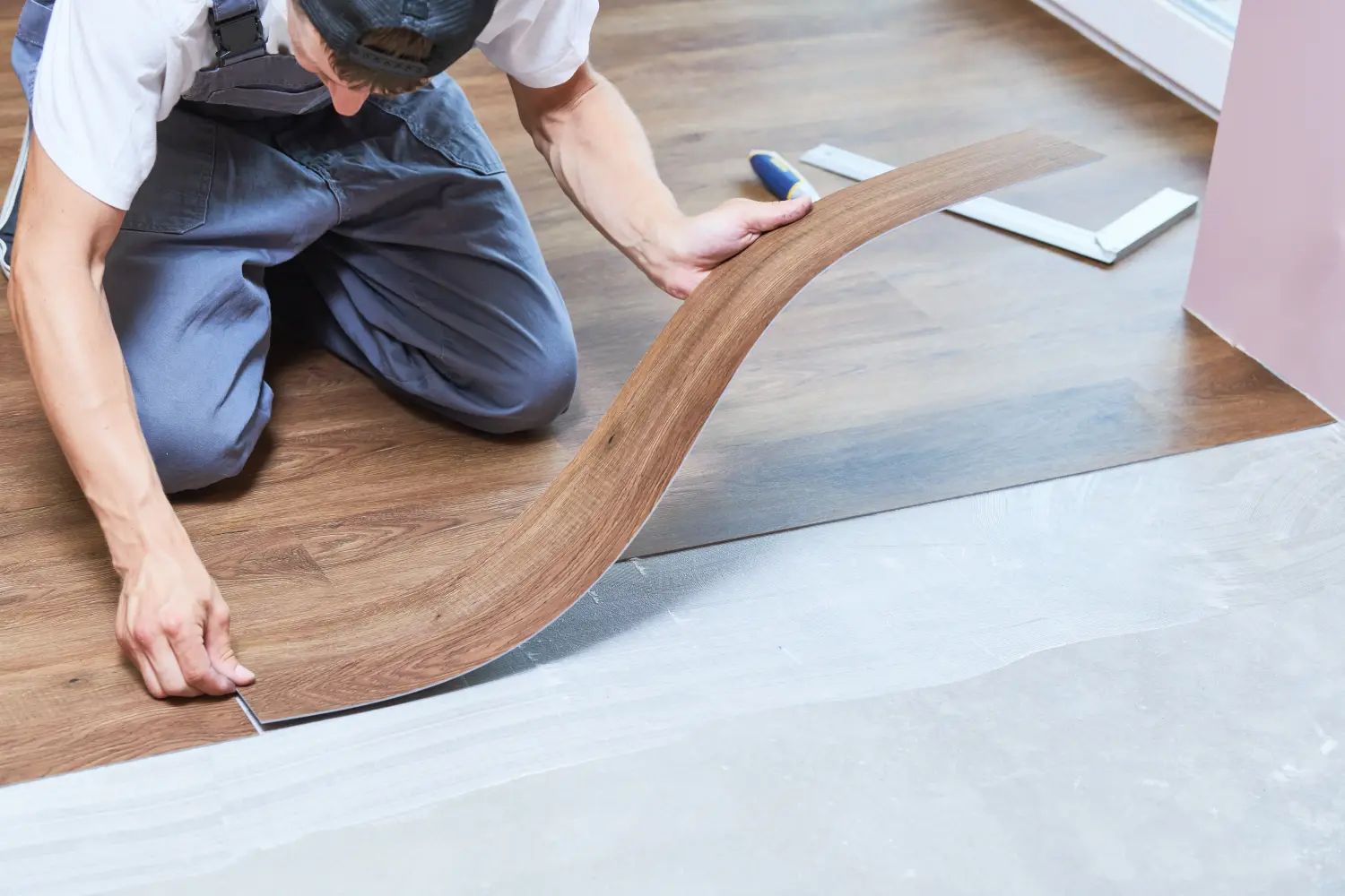 Arbeiter verbindet Vinyl-Bodenbelag bei der Renovierung seines Hauses